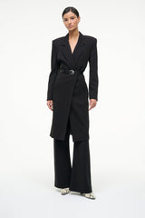 White snake-print ankle boots worn with a black wide-leg suit pant