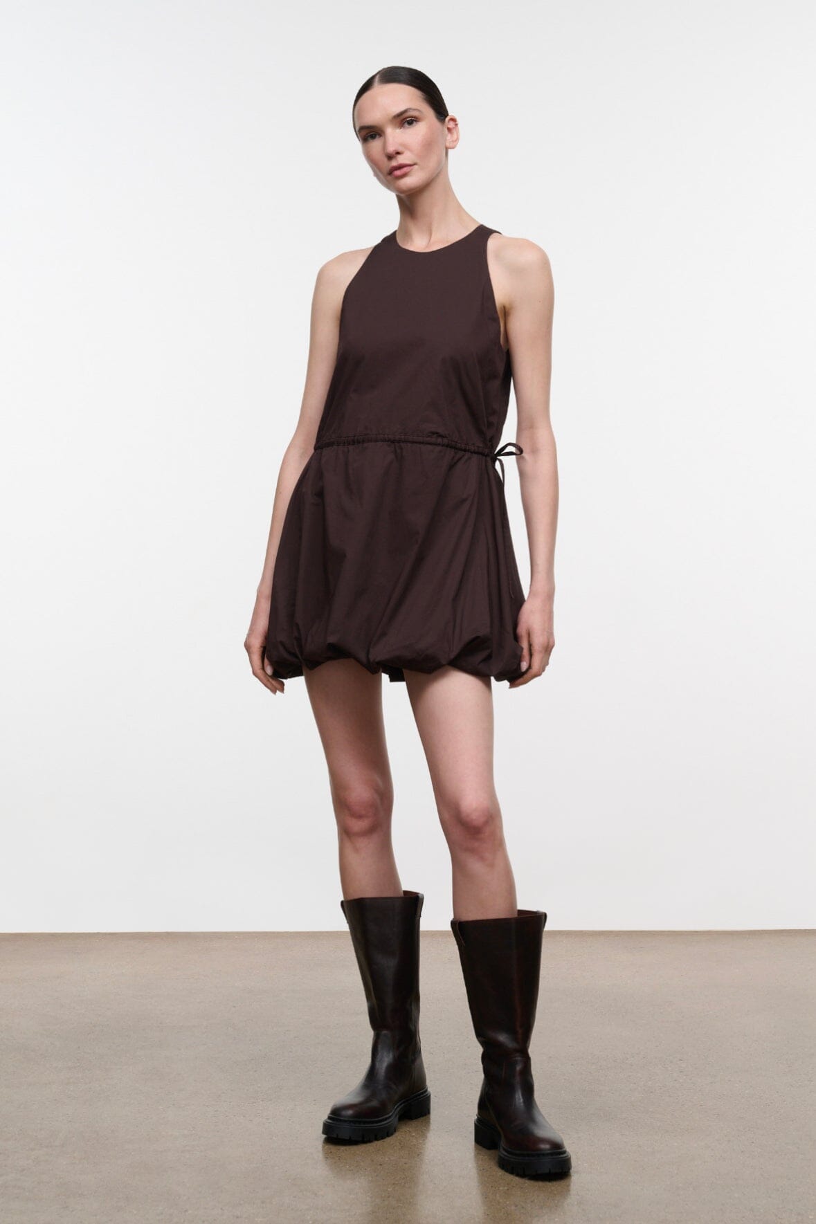Dark brown sleeveless mini dress with pleated puff skirt and drawstring waist ties