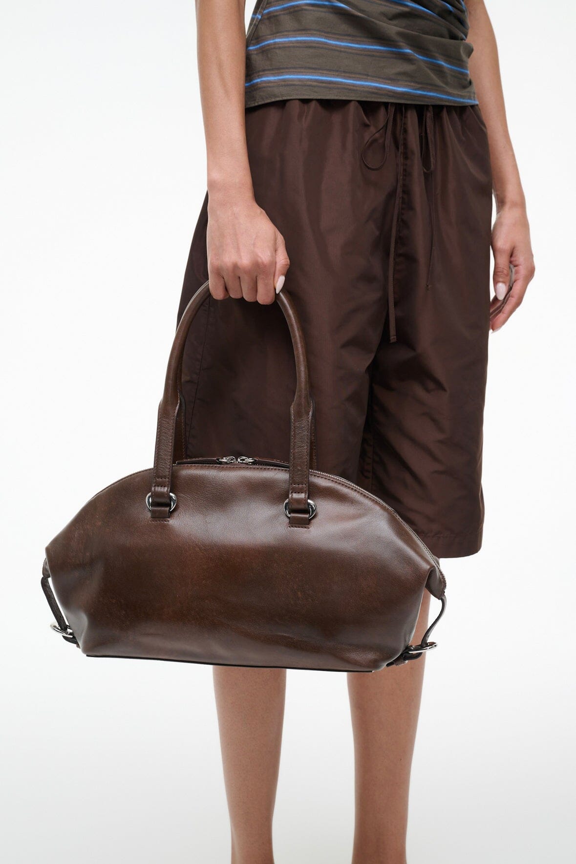 Distressed brown shoulder bag with top zipper and side strap loops, front view