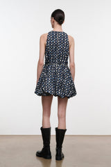Back view: navy sleeveless mini dress with teardrop print and flared pleated skirt