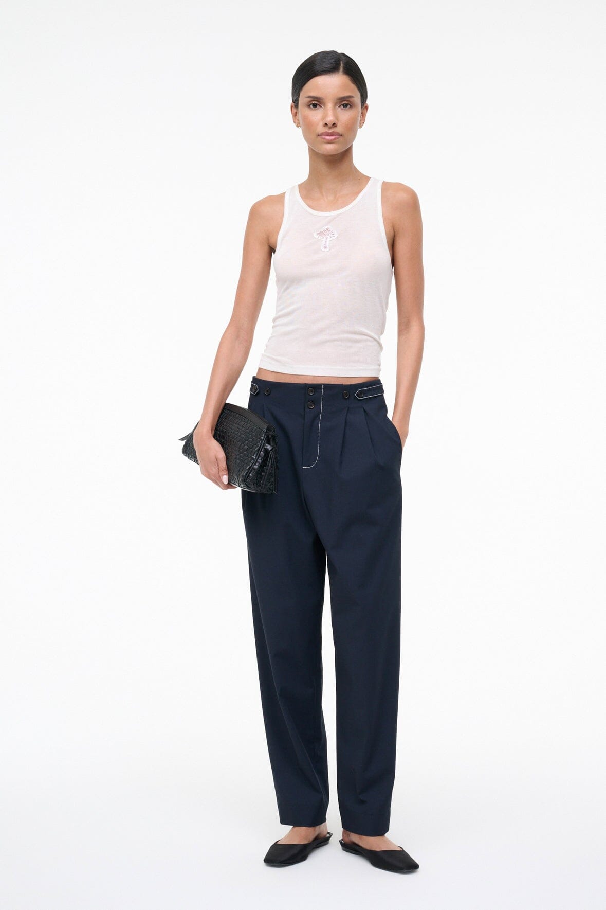 Ivory ribbed tank top with small front embroidery, worn as racerback