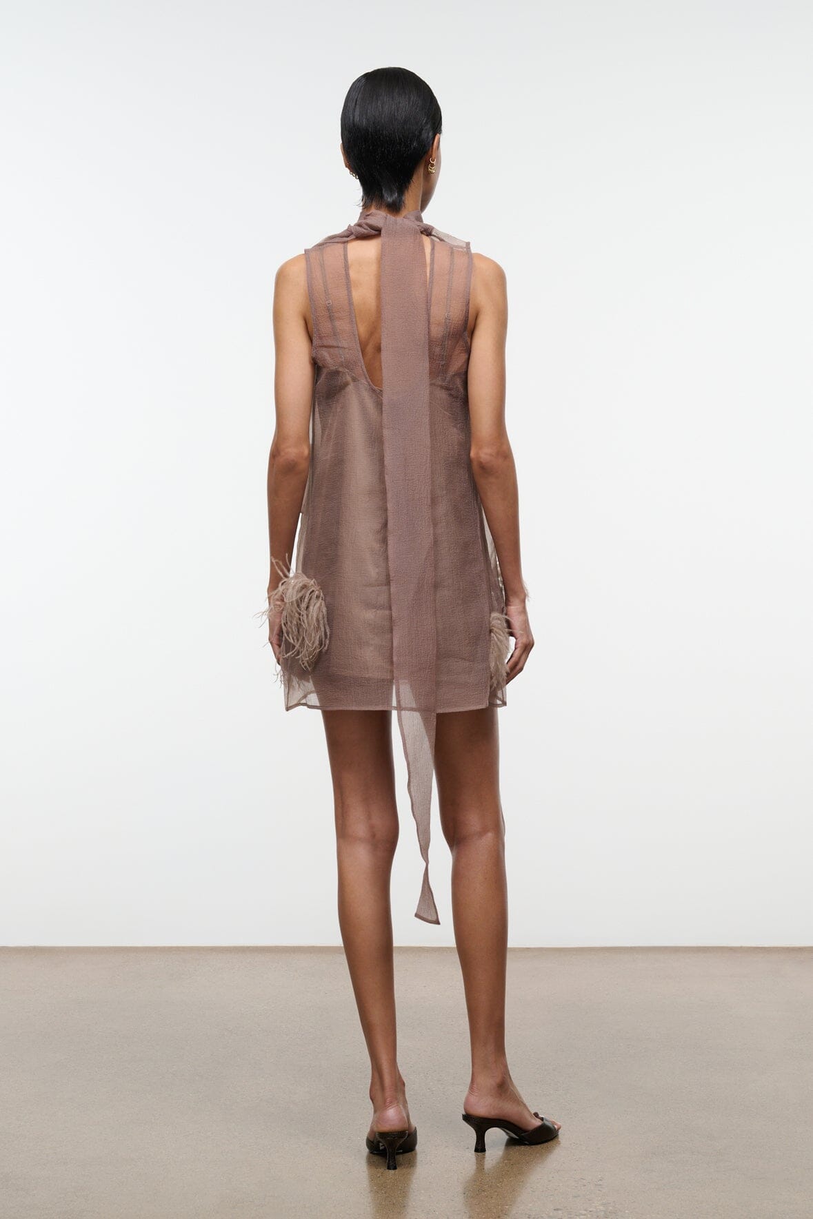 Taupe mini dress back view with high neckline and feathered trim along sleeves