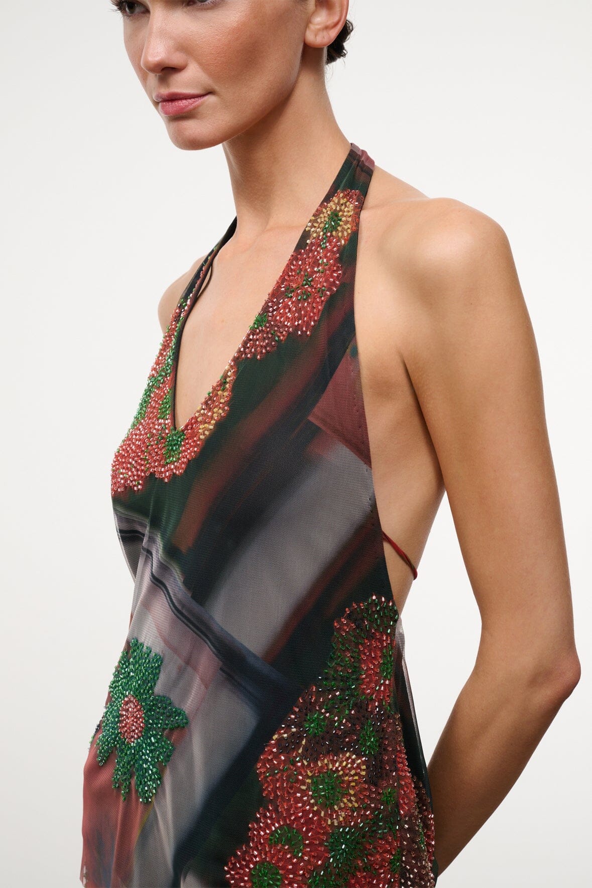 Halter sleeveless beaded top with deep V neckline, dark floral motifs and sheer fabric