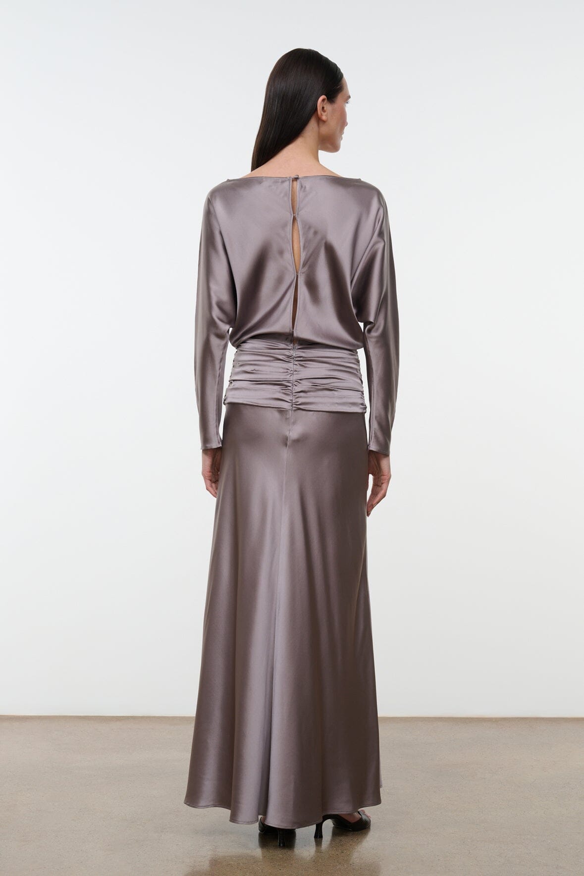 Back view of zinc satin silk dress with long sleeves, ruched waist, and full skirt
