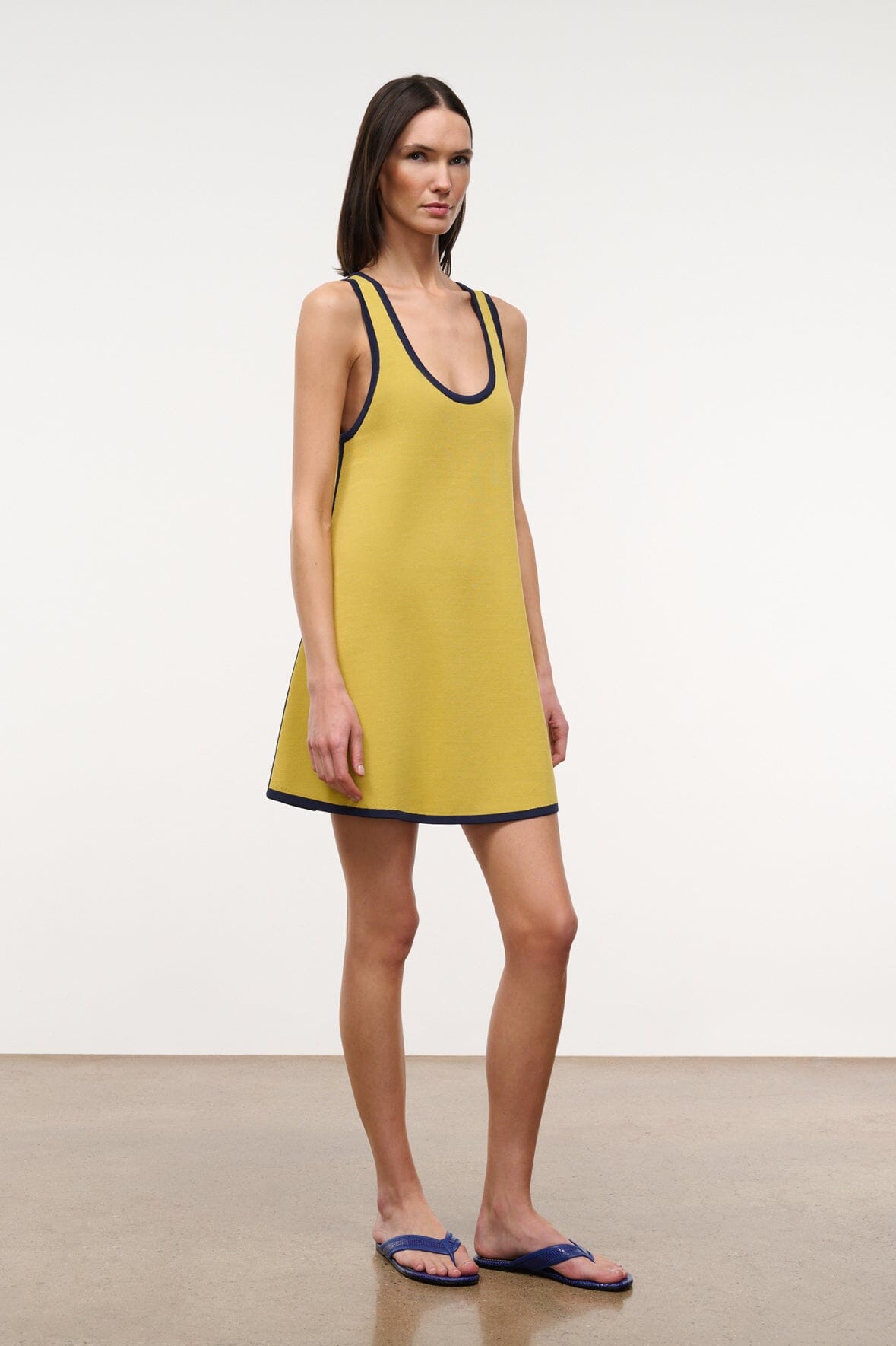 Sleeveless yellow dress with navy-trim U neckline and curved hem