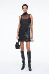Black mini bucket bag worn crossbody with top handles and silver-tone clasp