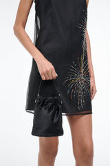 Black mini bucket bag carried at side with drawstring opening and metal clasp