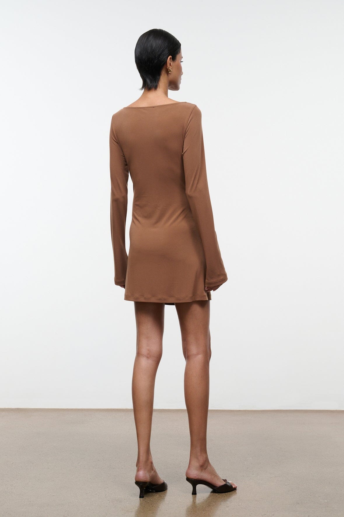 Women's brown draped long-sleeve mini dress, back view with center seam