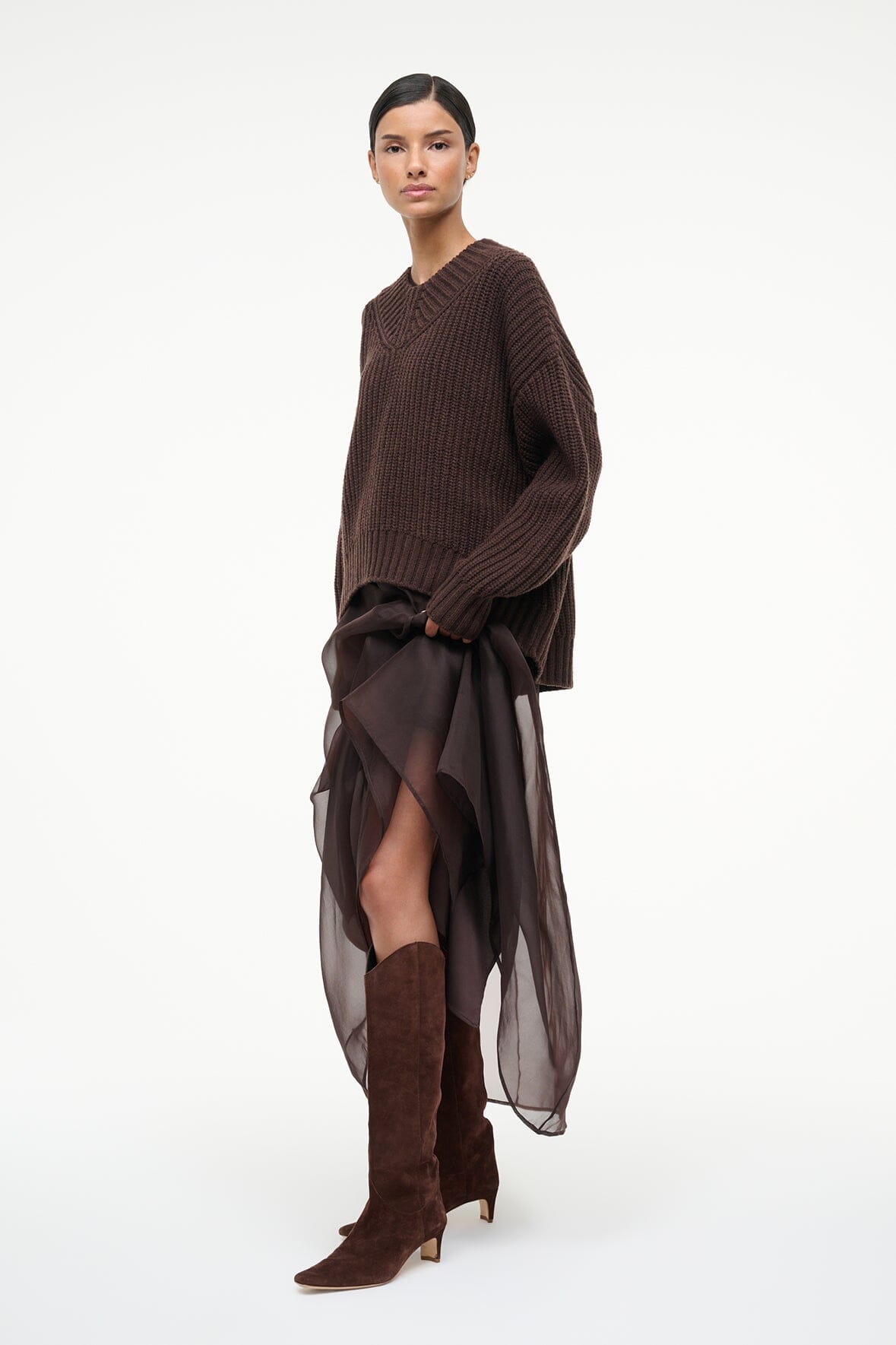 Mahogany suede knee-high boots on model with pointed toe and low stacked heel