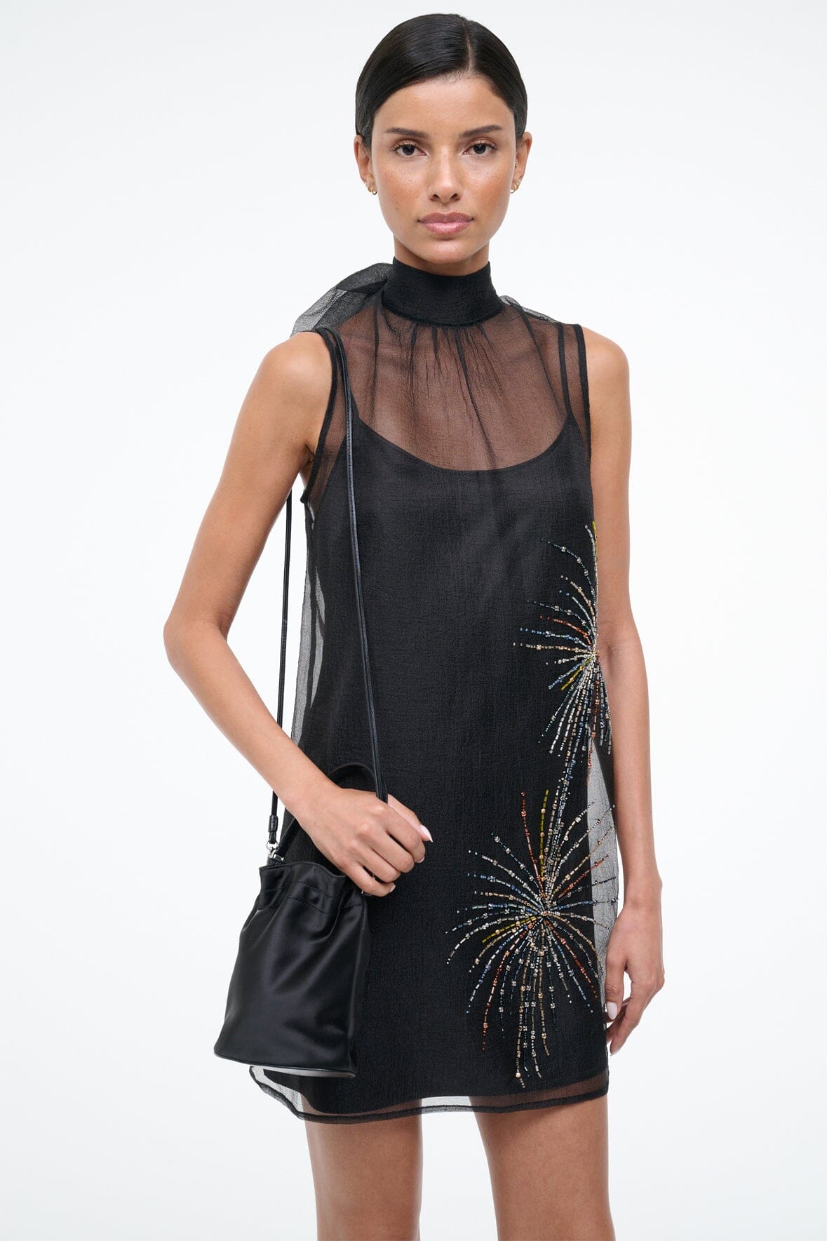 Black mini bucket bag in hand, showing drawstring top and silver-tone hardware