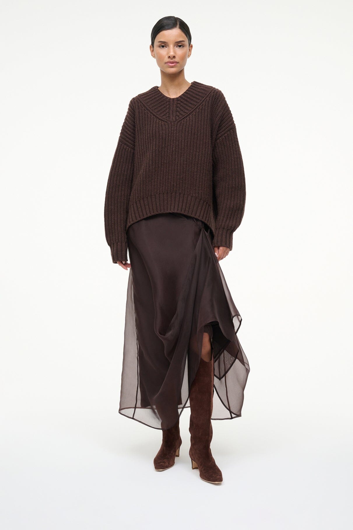 Mahogany suede knee-high boots on model with pointed toe and low heel