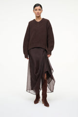 Mahogany suede knee-high boots on model with pointed toe and low heel