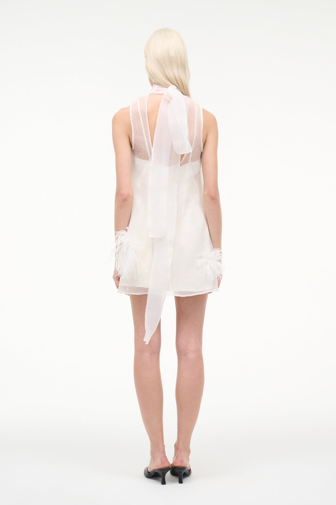 White mini dress back view with feather trim and sheer yoke