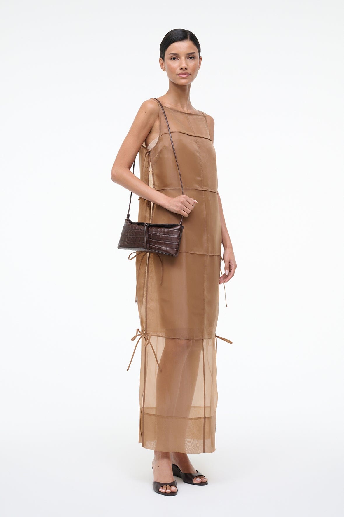 Dark brown croc-textured clutch with long strap, carried across front