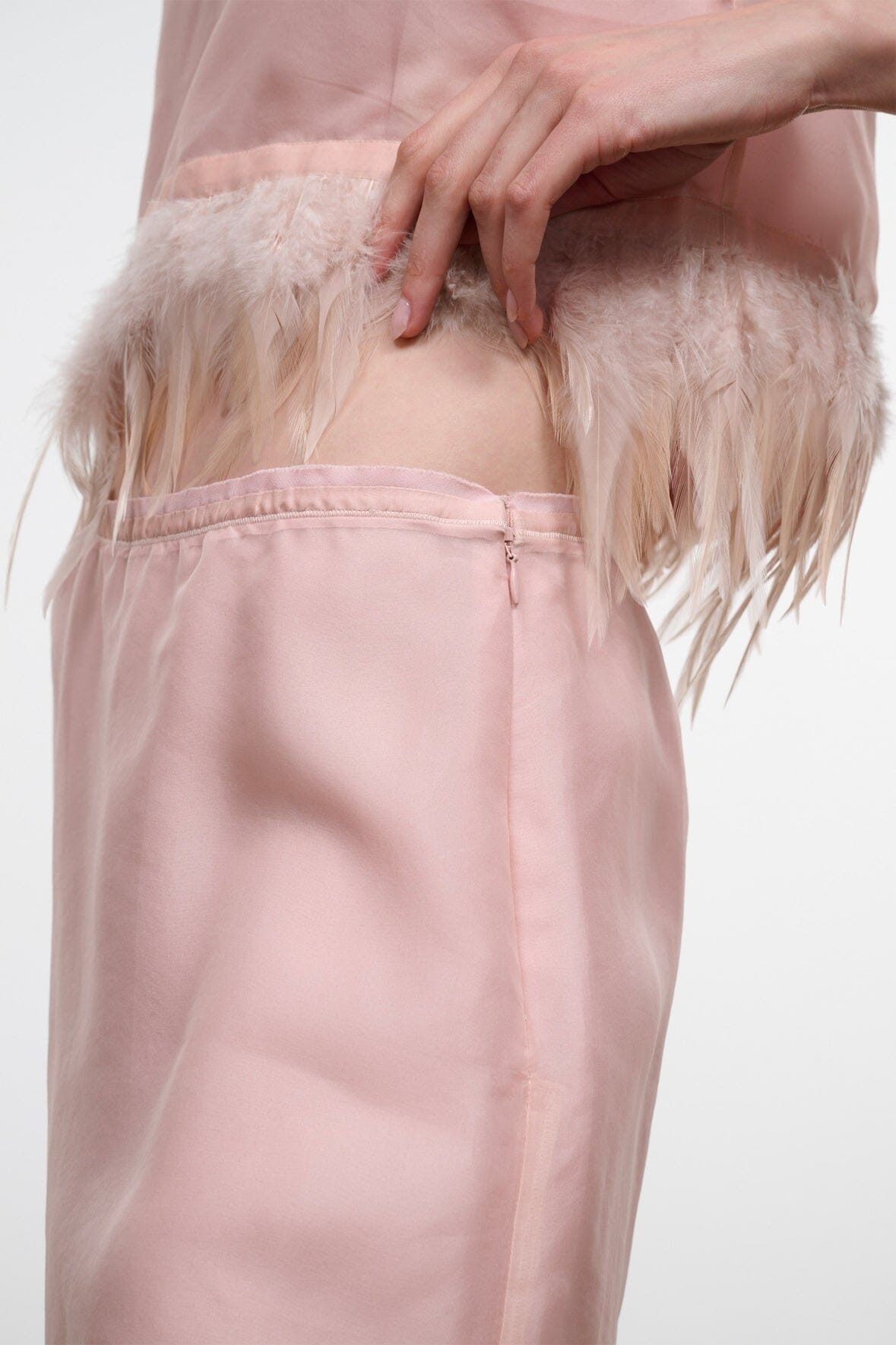 Light pink satin skirt with feather fringe hem and center-front seam