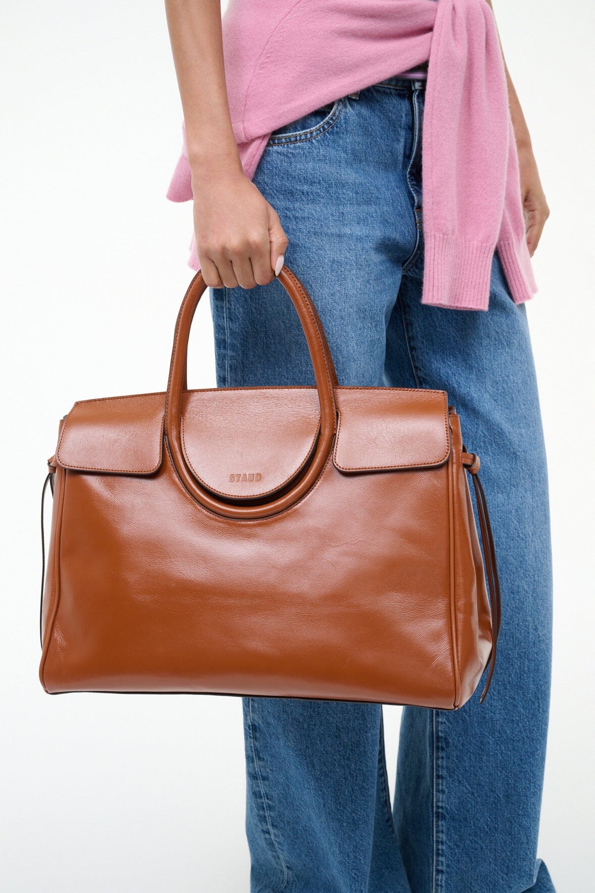 Brown carryall handbag with arched ring strap and two front flap pockets