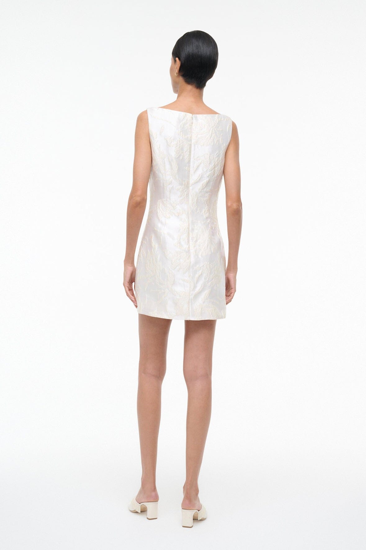 Ivory sleeveless shift dress with textured leaf print, back view.