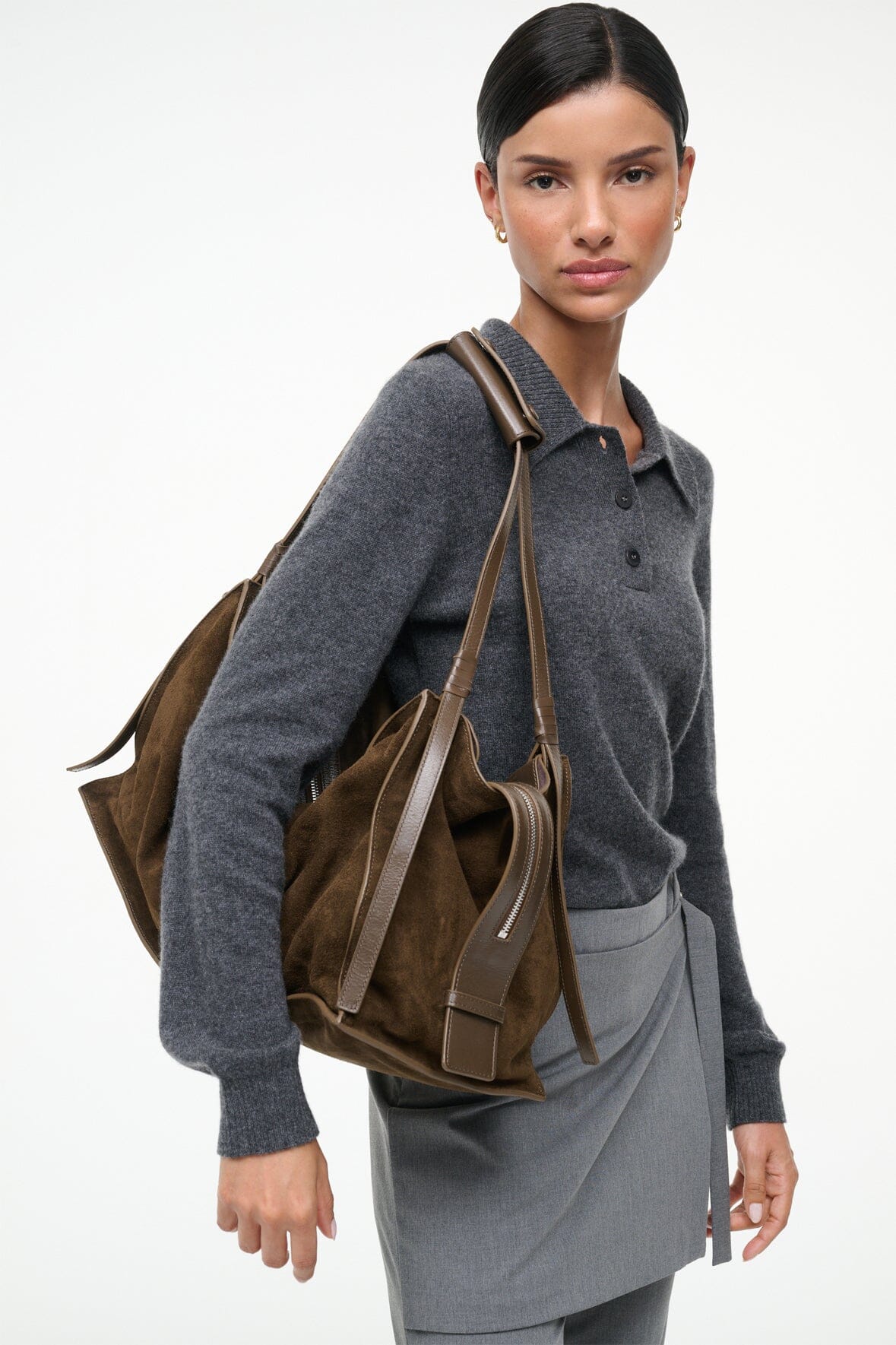 Truffle suede shoulder bag worn with top handles and side tassel details