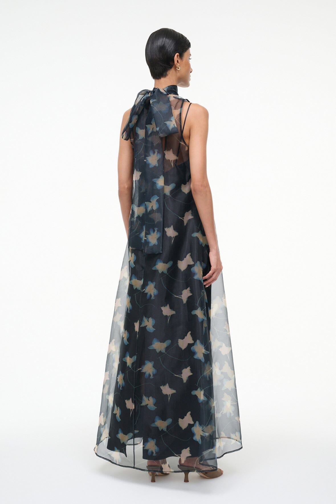 Back view maxi dress with sheer dark fabric and pale bird print, long flowing silhouette