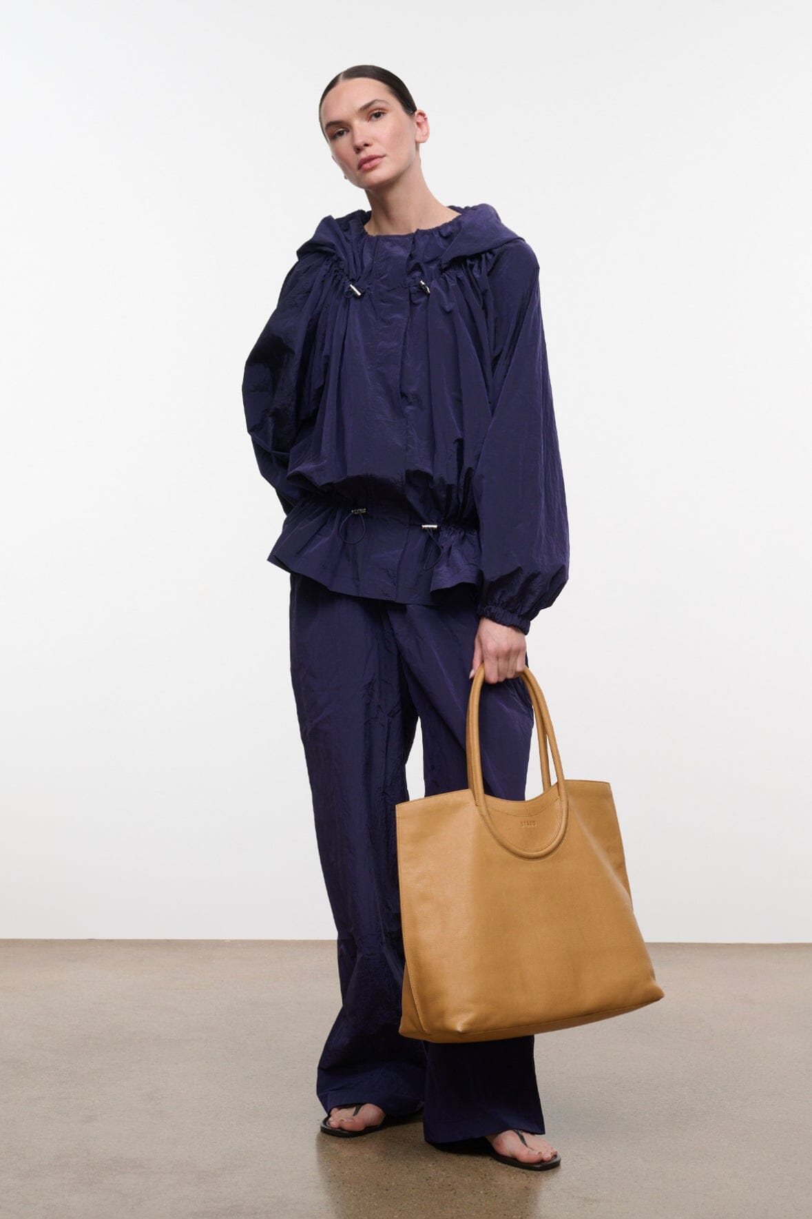 FLO pants in dark navy wide-leg silhouette with elastic waist, styled with tote