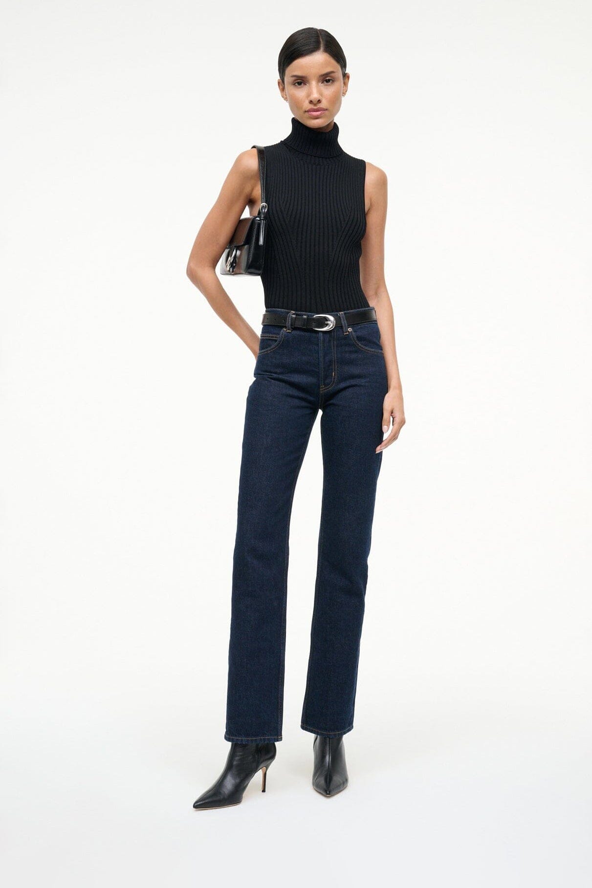 Black leather ankle boots with pointed toe and slim high heel worn with jeans