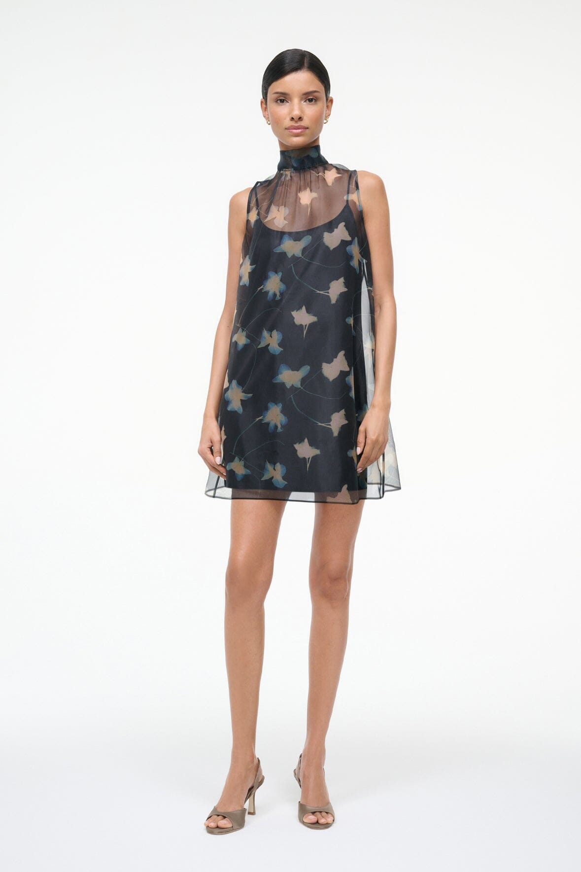Black sleeveless mini dress with high mock neck and floating bird graphic pattern