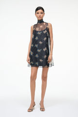 Black sleeveless mini dress with high mock neck and floating bird graphic pattern