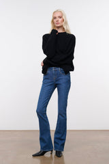 Stone blue denim flare jeans on model, mid-rise straight wide-leg silhouette