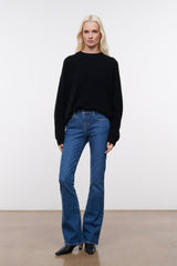 Stone blue denim flare jeans on model, mid-rise with straight wide-leg shape