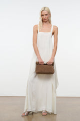 Husk brown cuff clutch with silver snap hardware held at the side by model