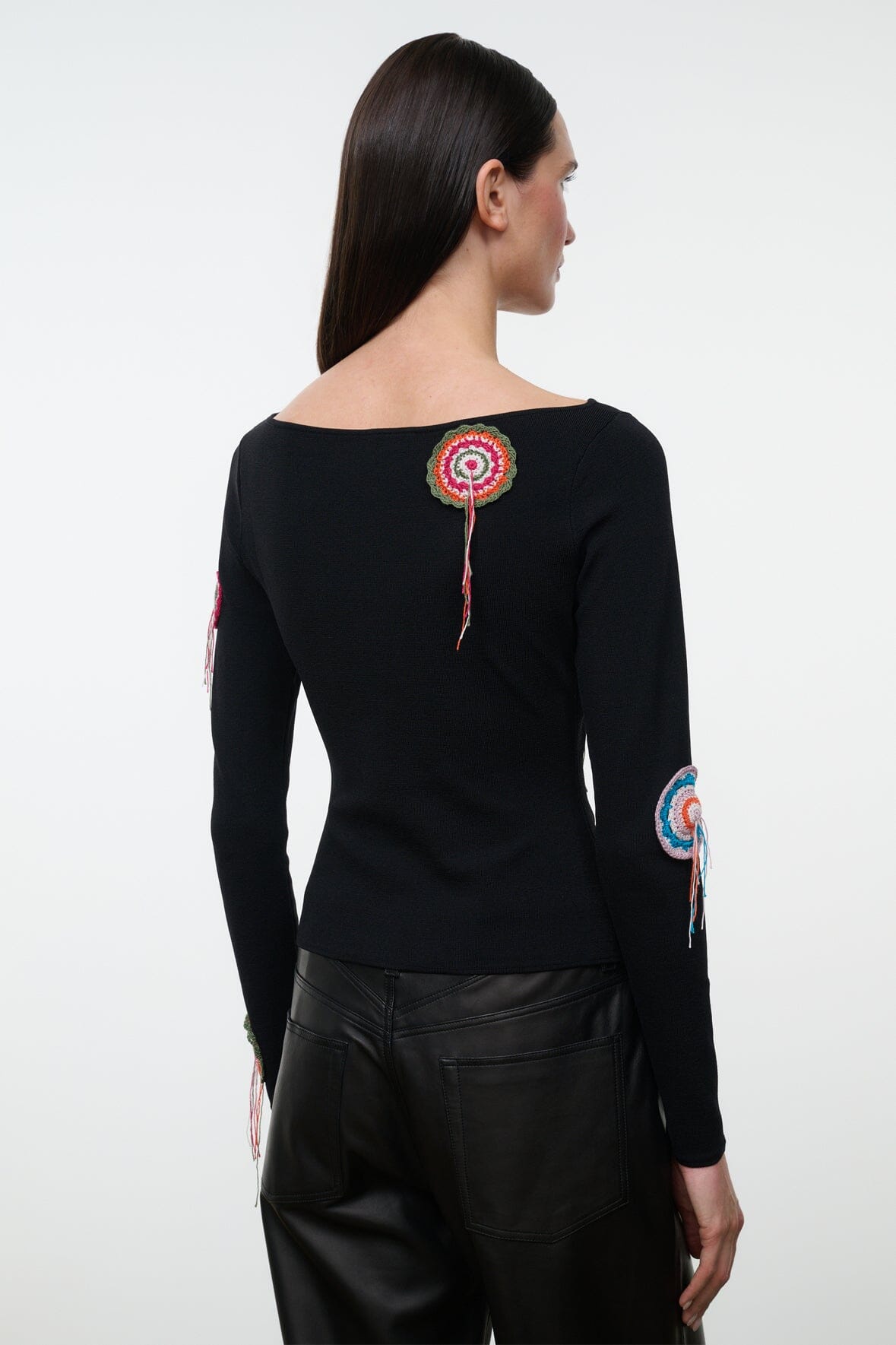 Black long-sleeve top with multicolor circular embroidery and dangling tassels, back