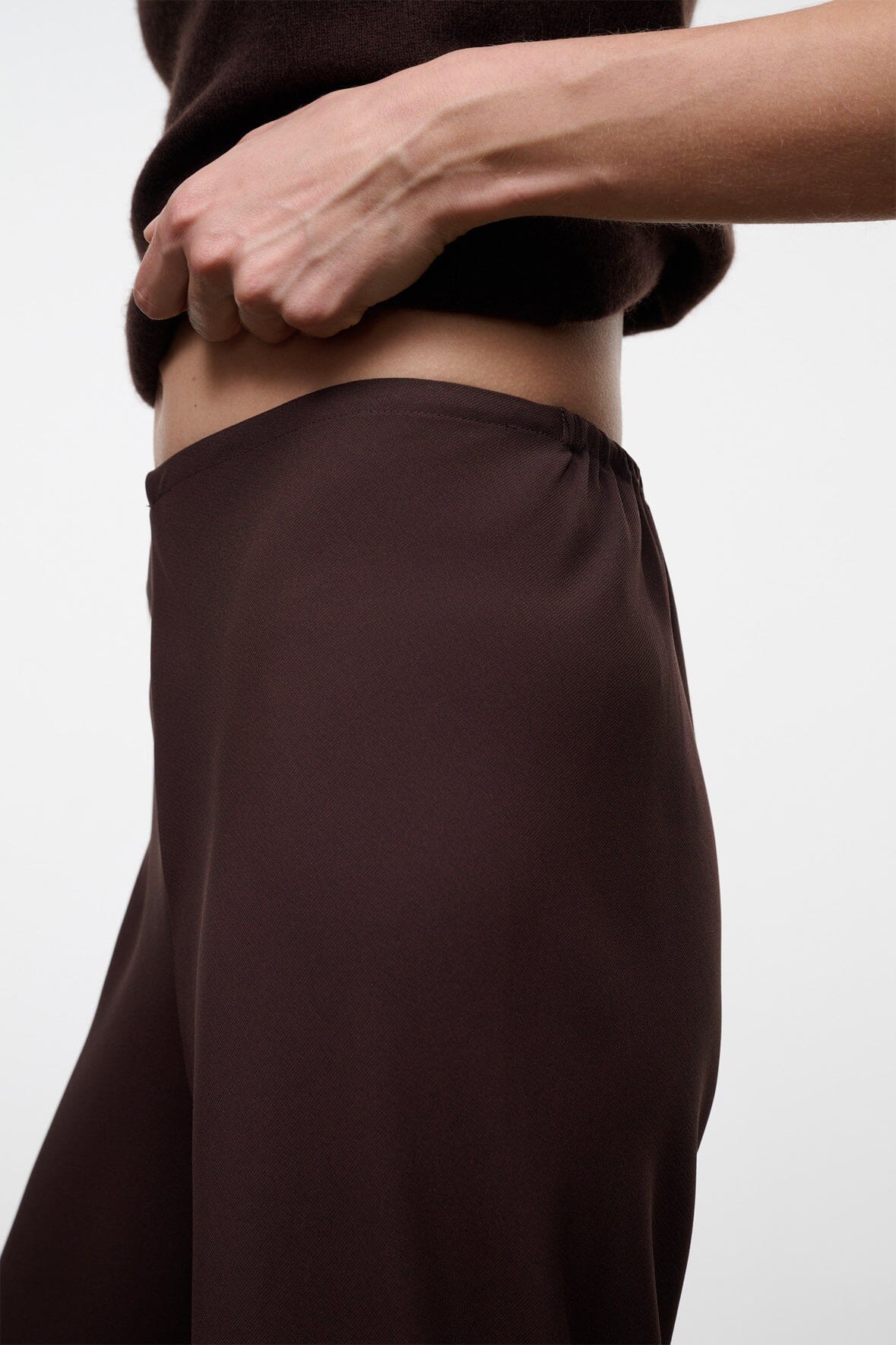 Women's high-rise wide-leg pants, dark brown waistband and smooth drape close-up