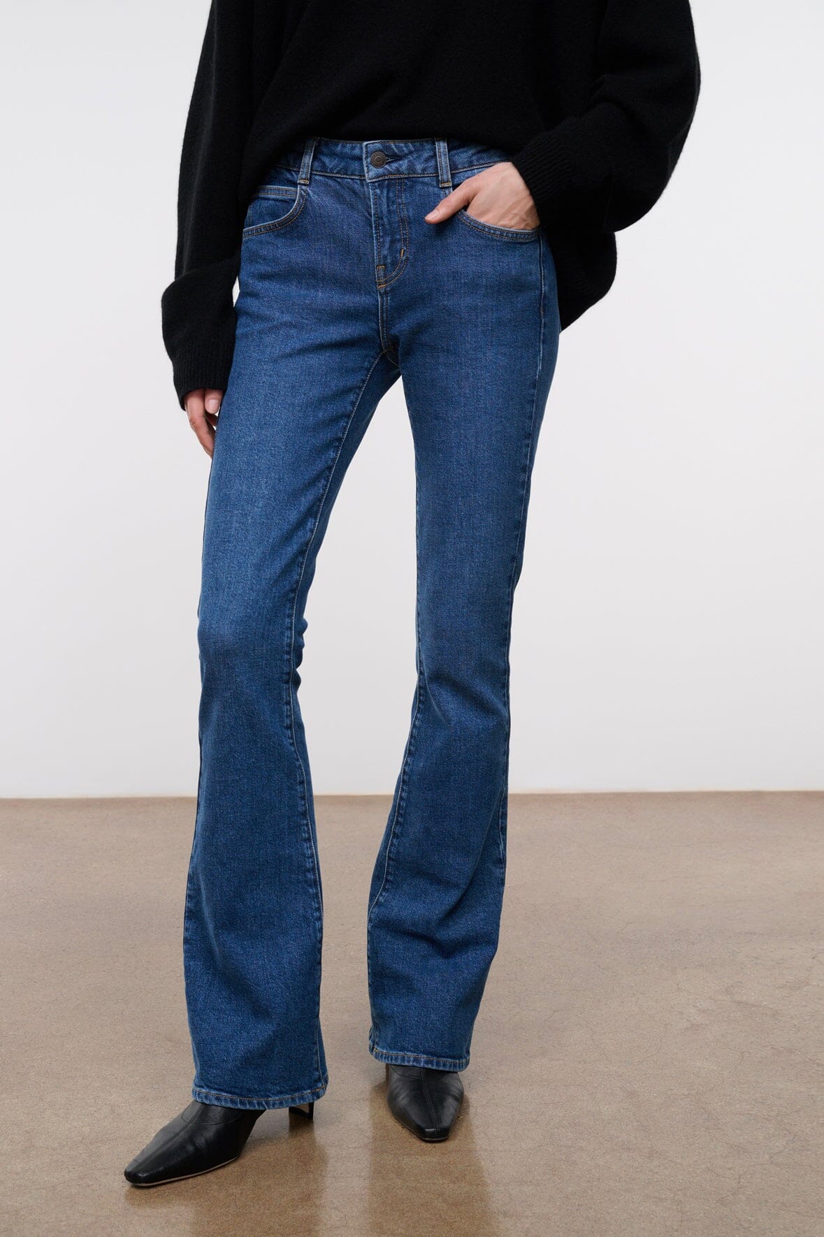 Women's stone blue stretch flare jeans with visible front seams and long flared leg
