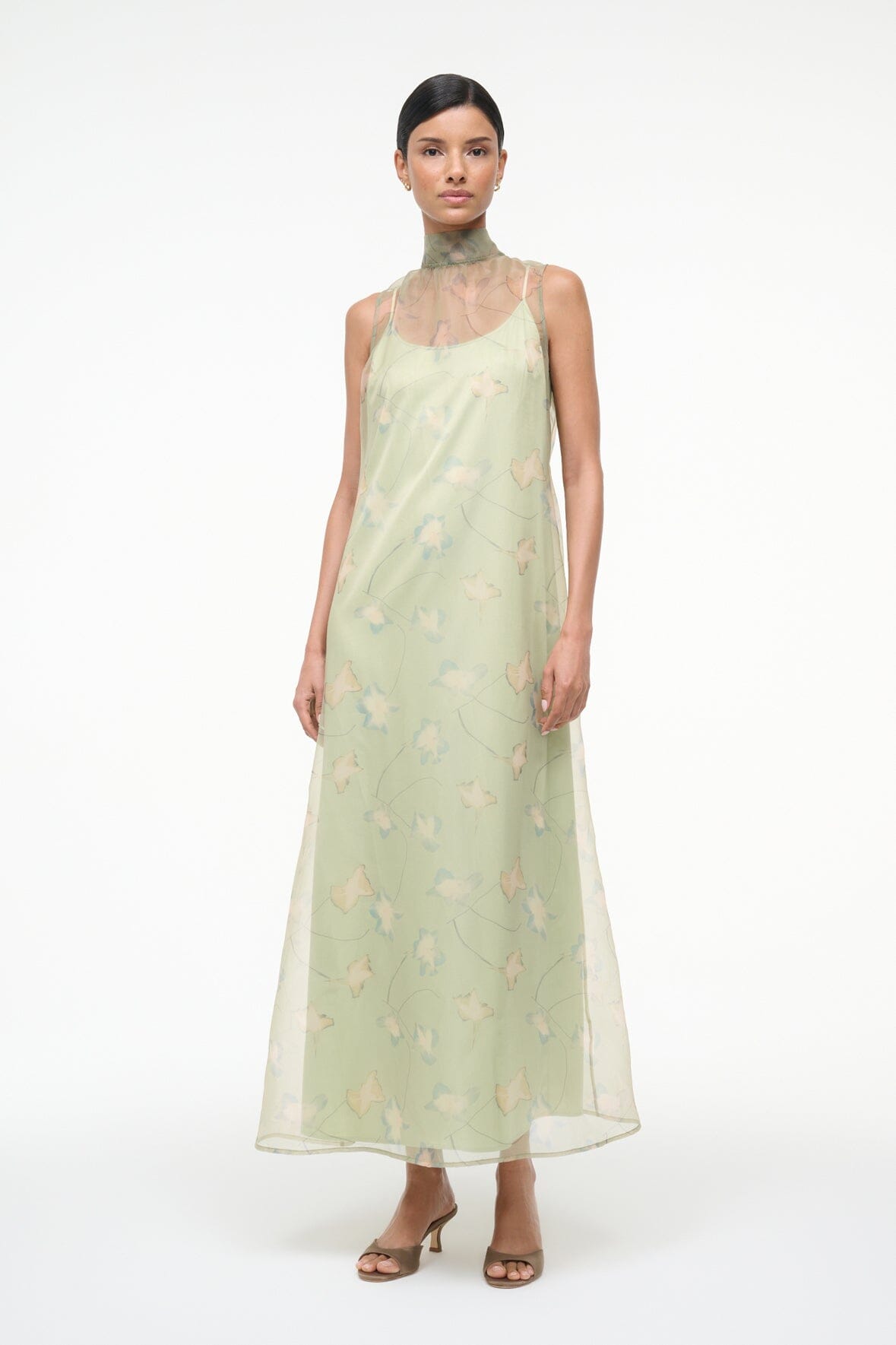 Light green sleeveless maxi dress with botanical print, high neck, and straight hem
