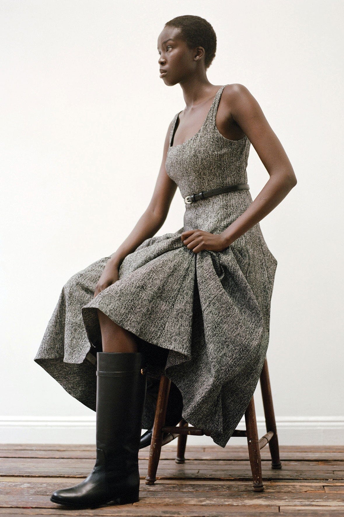 Black riding boots on model sitting, showing full-height shaft