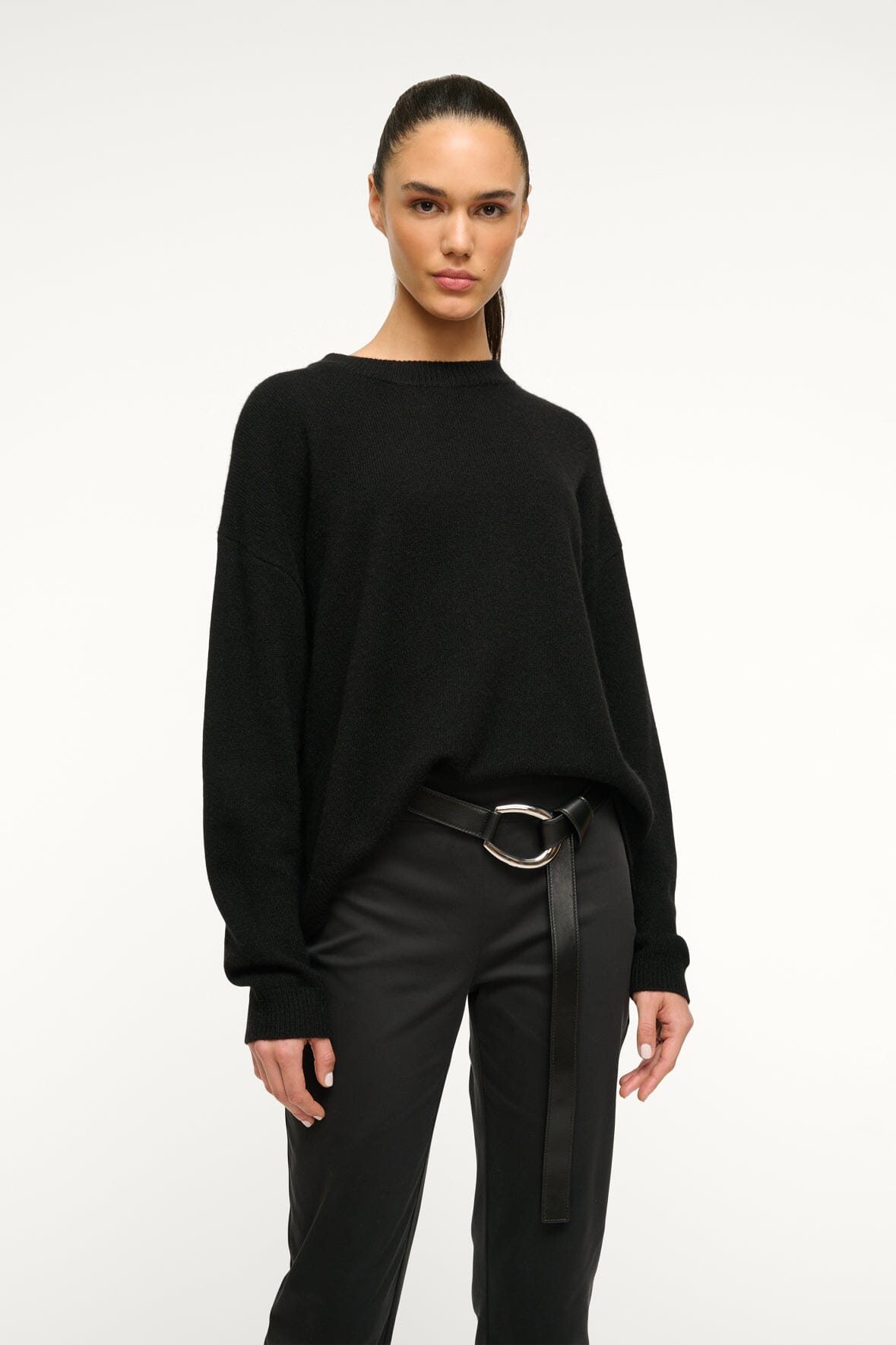 Black wrap belt with silver-tone ring buckle worn at the waist