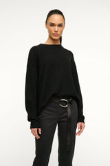 Black wrap belt with silver-tone ring buckle worn at the waist