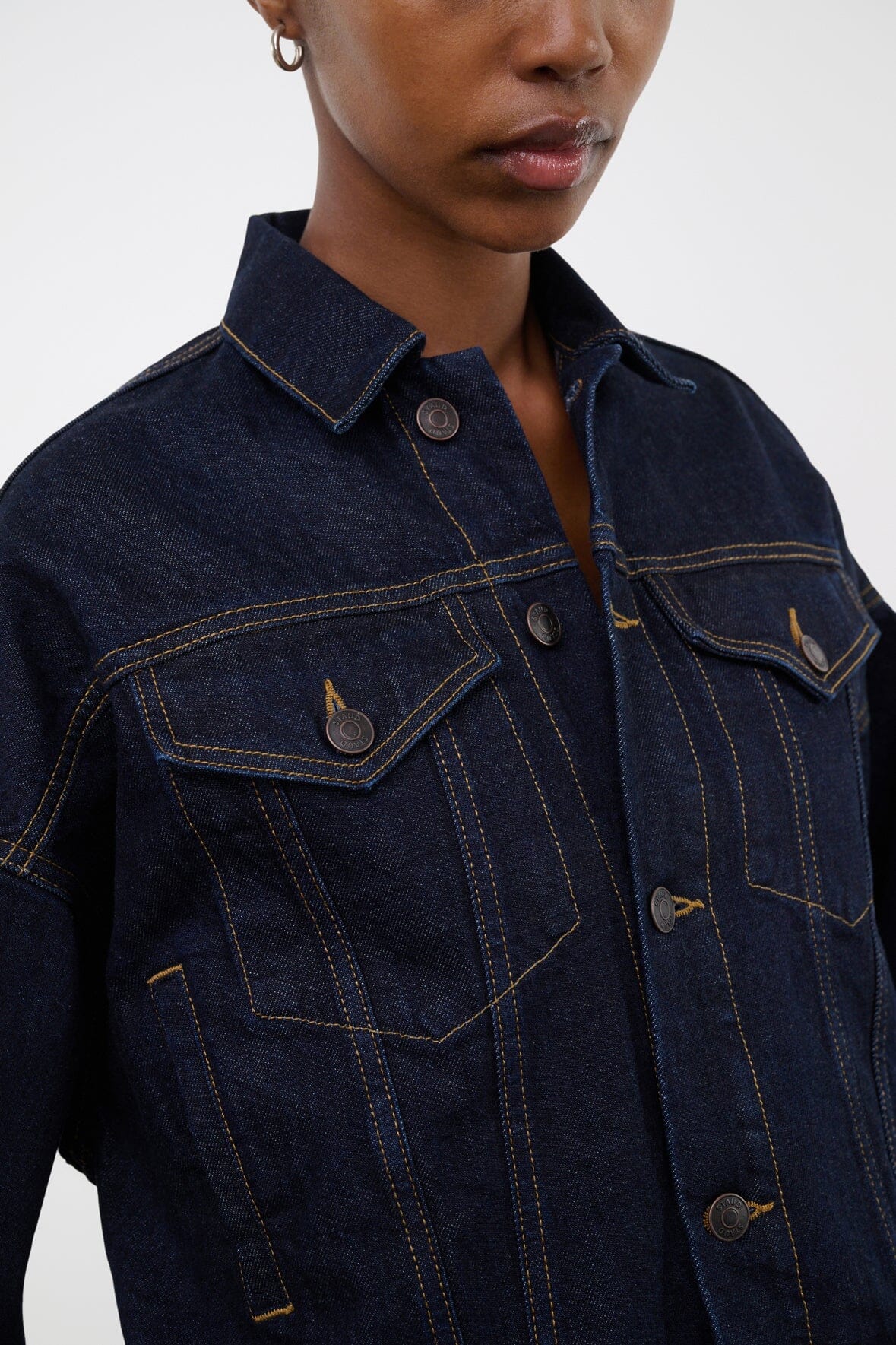 Indigo denim jacket collar and chest with contrast topstitching and buttoned flap pockets