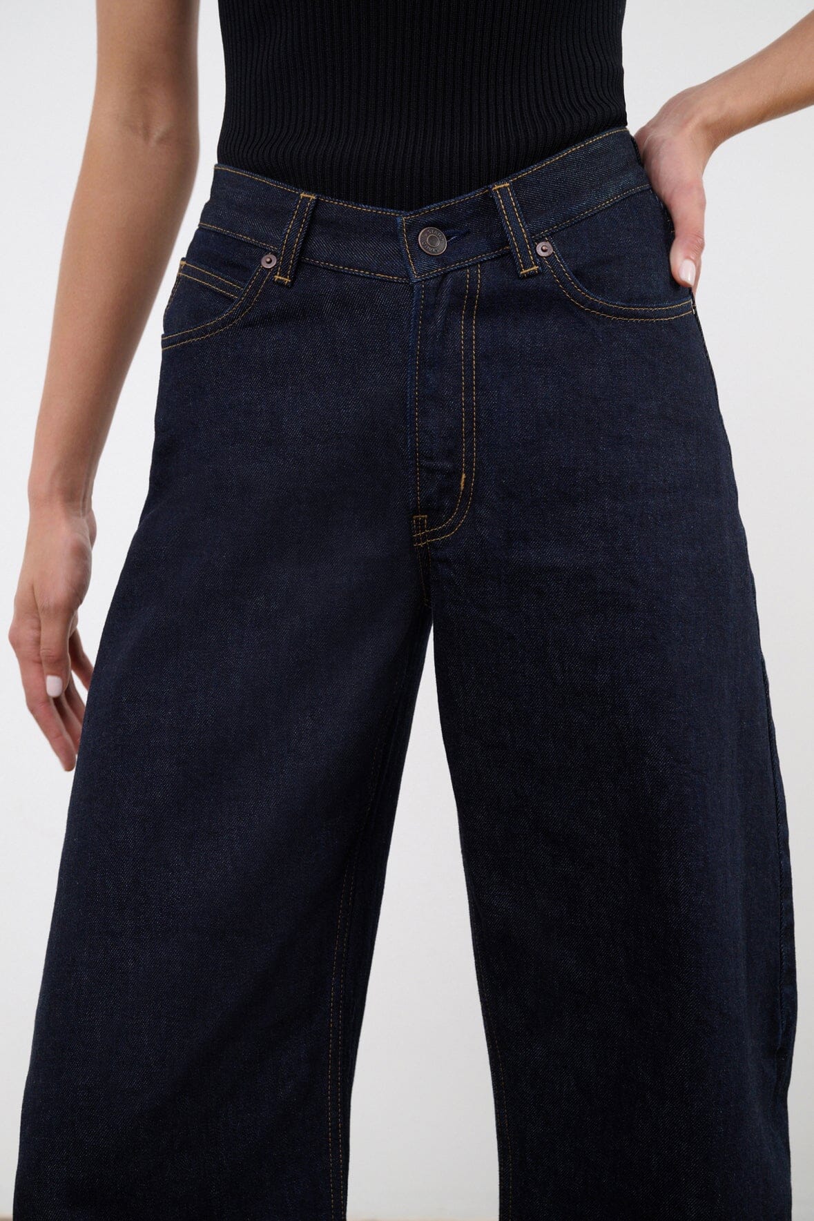 Indigo barrel-leg jeans on model with high-rise waist and button fly