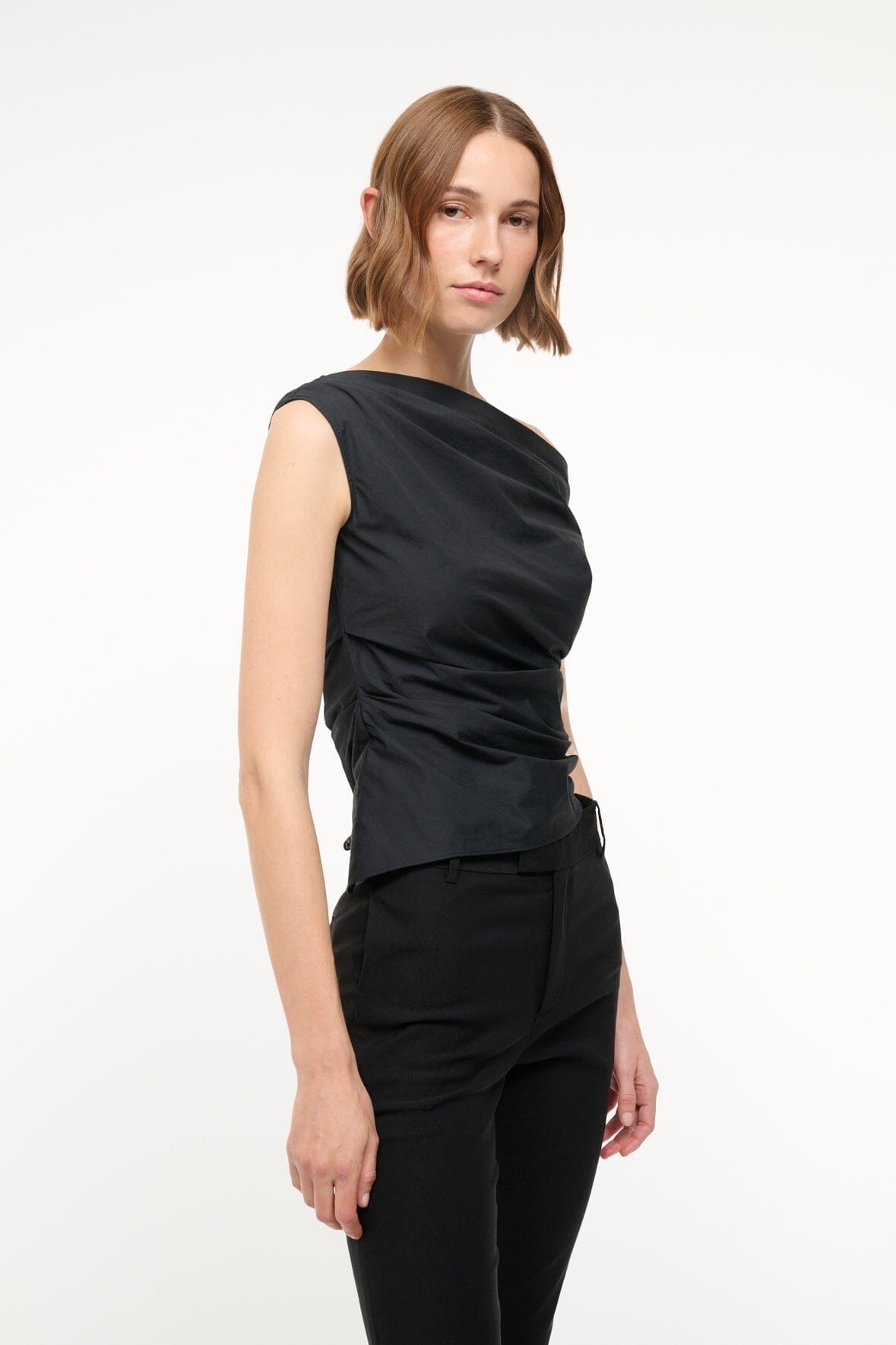 Black sleeveless draped top with one-shoulder off-shoulder neckline