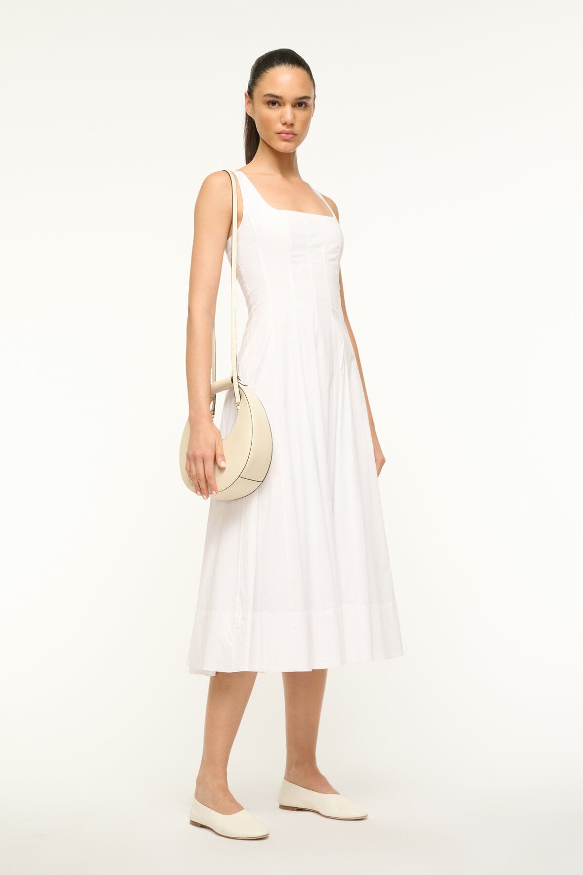 Cream mini moon bag worn crossbody with top handle