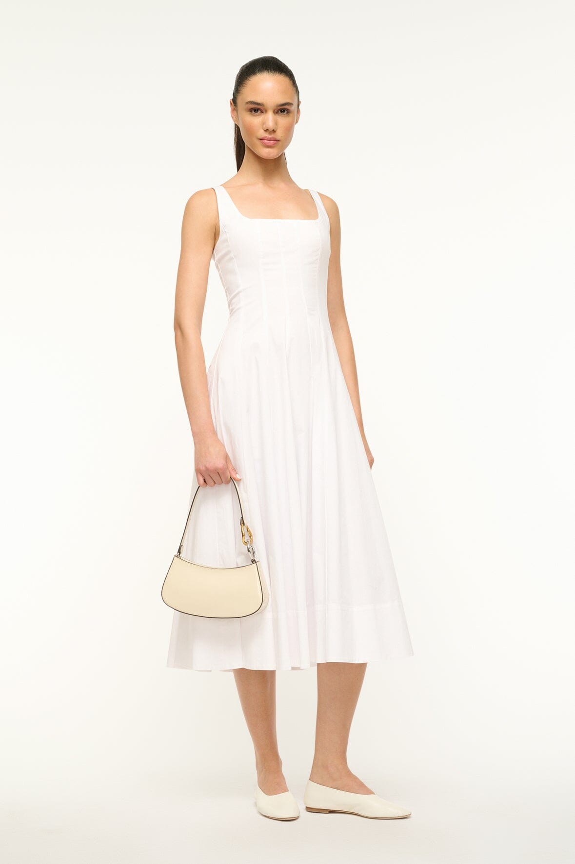 Cream shoulder hobo bag with gold hardware, held by model