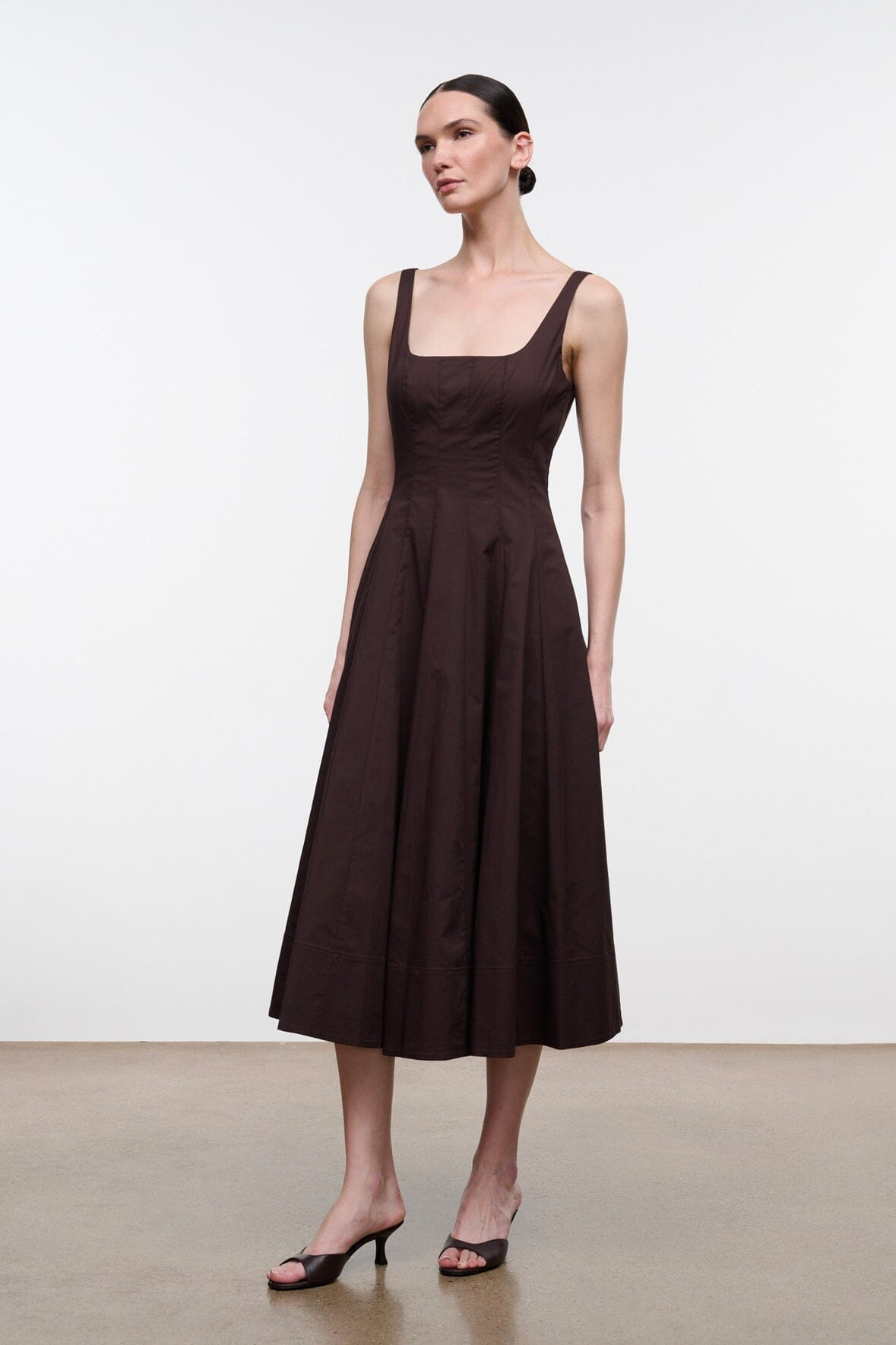Dark brown sleeveless midi dress with fitted bodice and flared pleated skirt