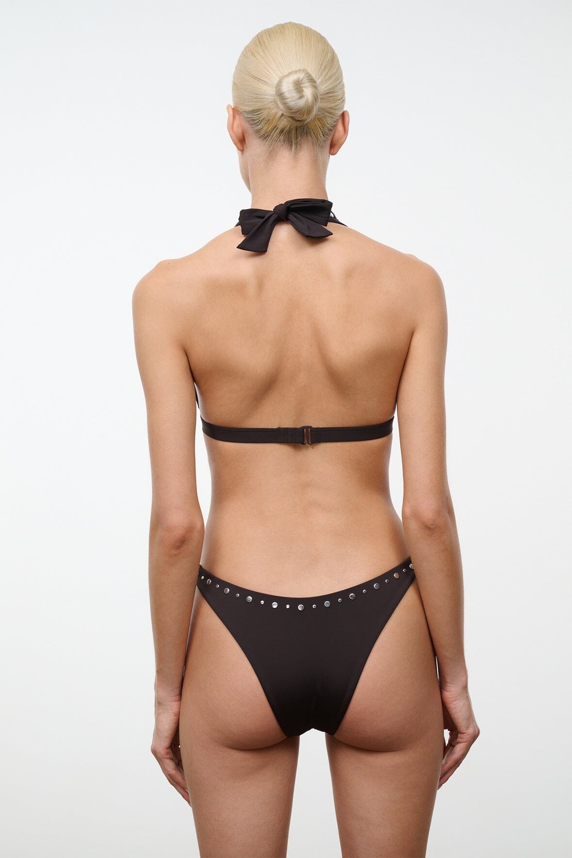 Dark bikini top with racer-back straps and silver studs, bow at center back