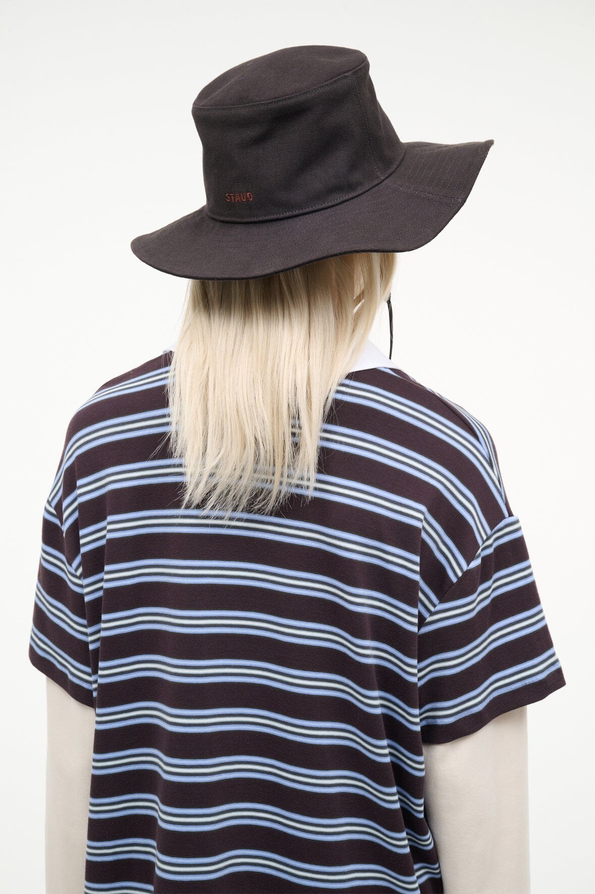 Dark brown bucket hat from behind, wide brim with stitched logo and cords