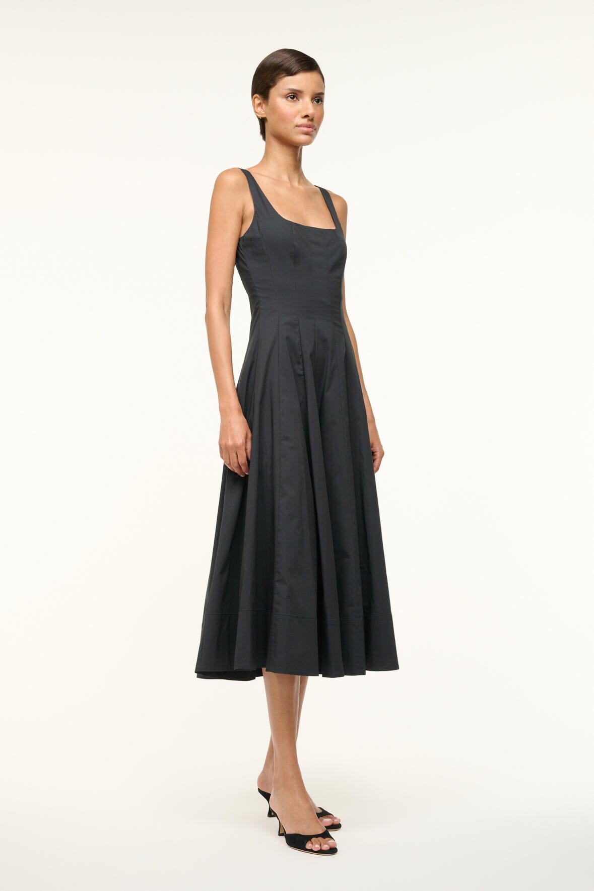 Black sleeveless midi dress with thin straps and pleated, flared skirt