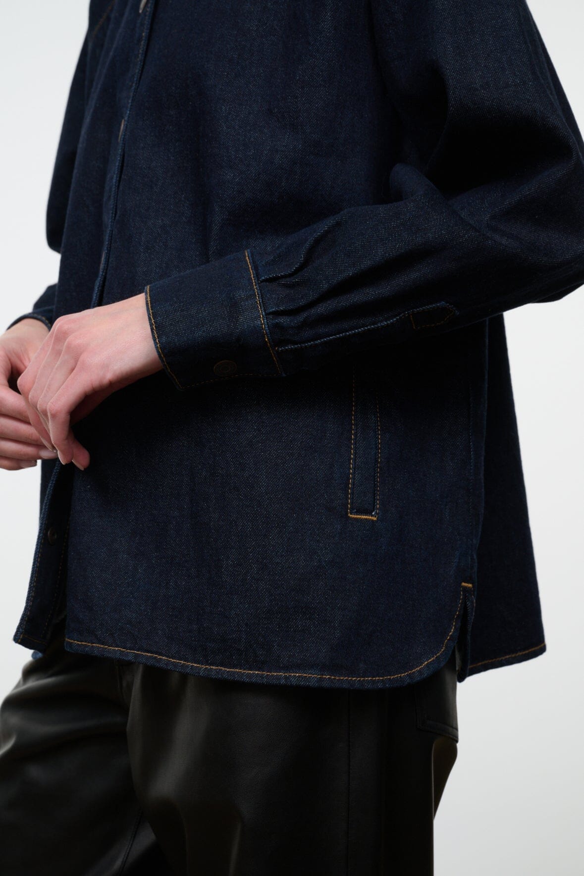 Indigo denim shirt jacket sleeve and hem detail with contrast topstitching and pocket