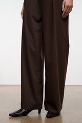 Dark brown ankle boots with pointed toe and subtle snake pattern; wide-leg trousers