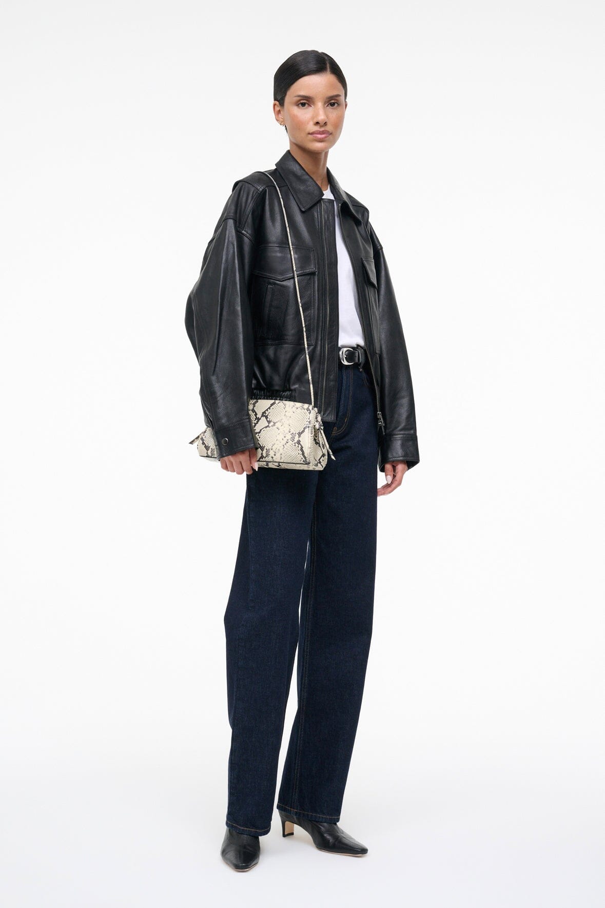 Convertible clutch bag, white snake-print, shown crossbody on model