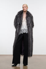 Black snake-print ankle boots with pointed toe and low heel under long coat